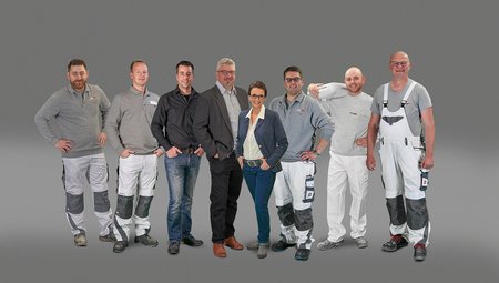 ISOTEC Team steht vor neutralem Hintergrund